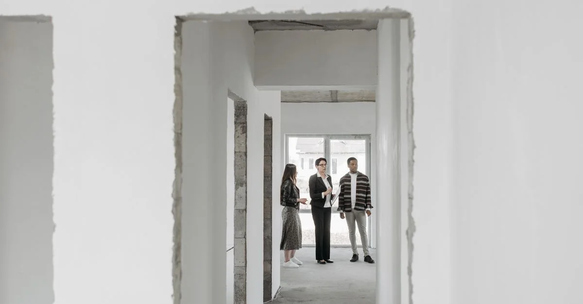 Agent immobilier présentant une nouvelle maison à des acheteurs potentiels. Vue intérieure moderne.