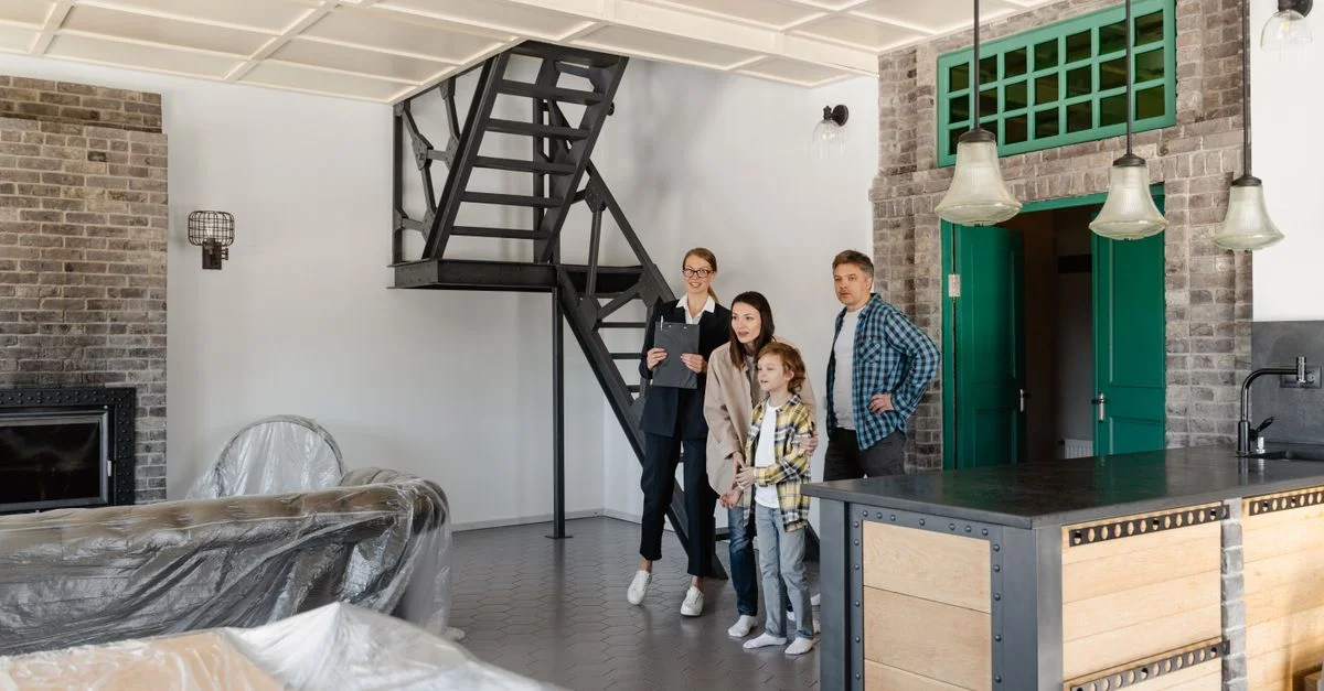 Une famille explorant une maison moderne avec un agent immobilier, mettant en avant un design intérieur industriel.