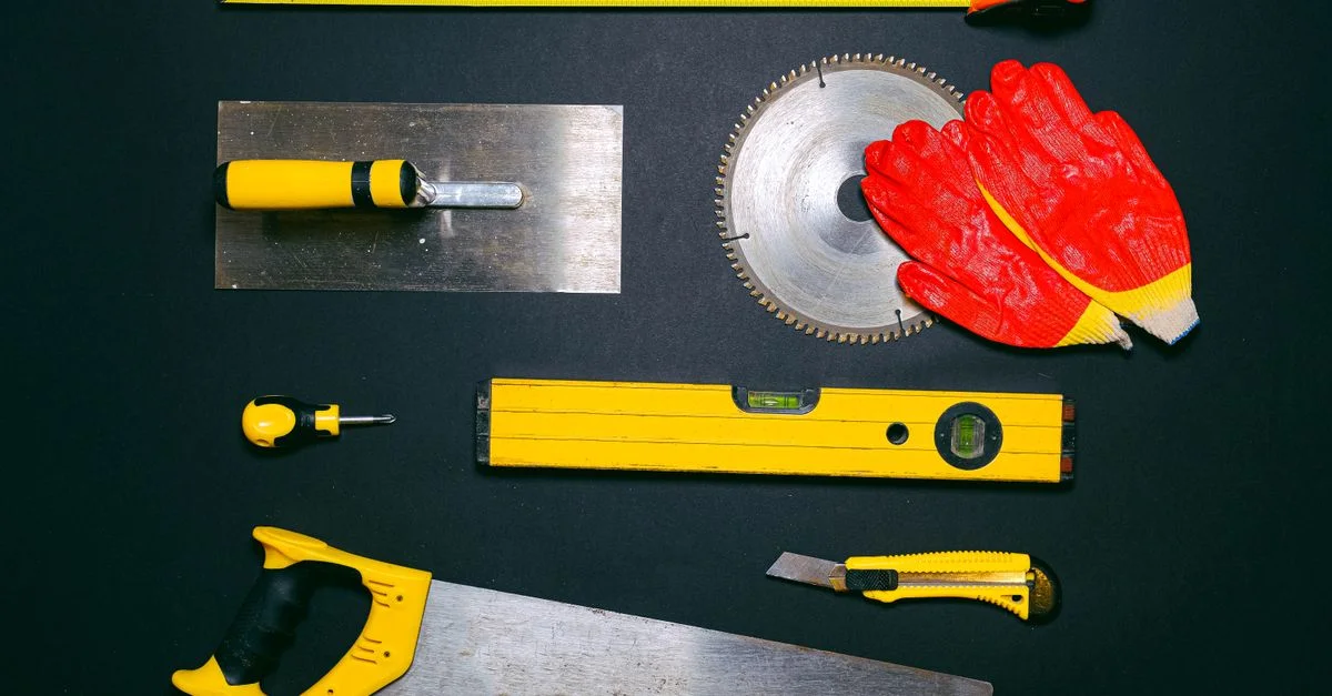 Un ensemble d'outils à main de construction disposés en plan fixe sur un fond sombre. Idéal pour les projets de bricolage.