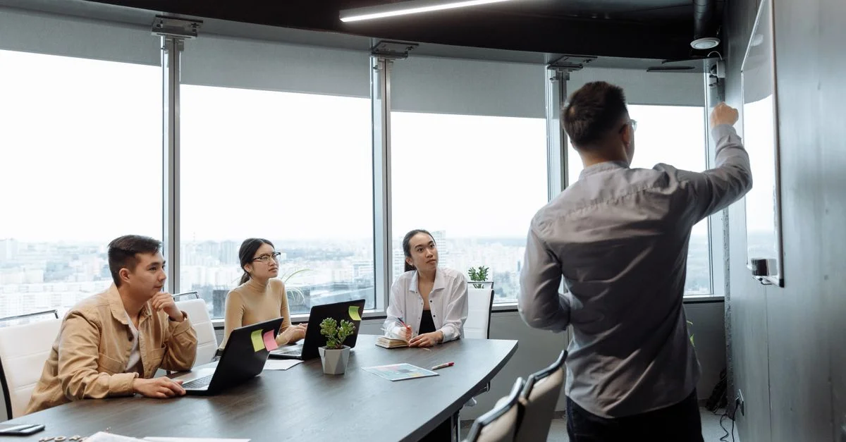 Des collègues dans une salle de réunion discutant d'une présentation avec vue sur la ville.